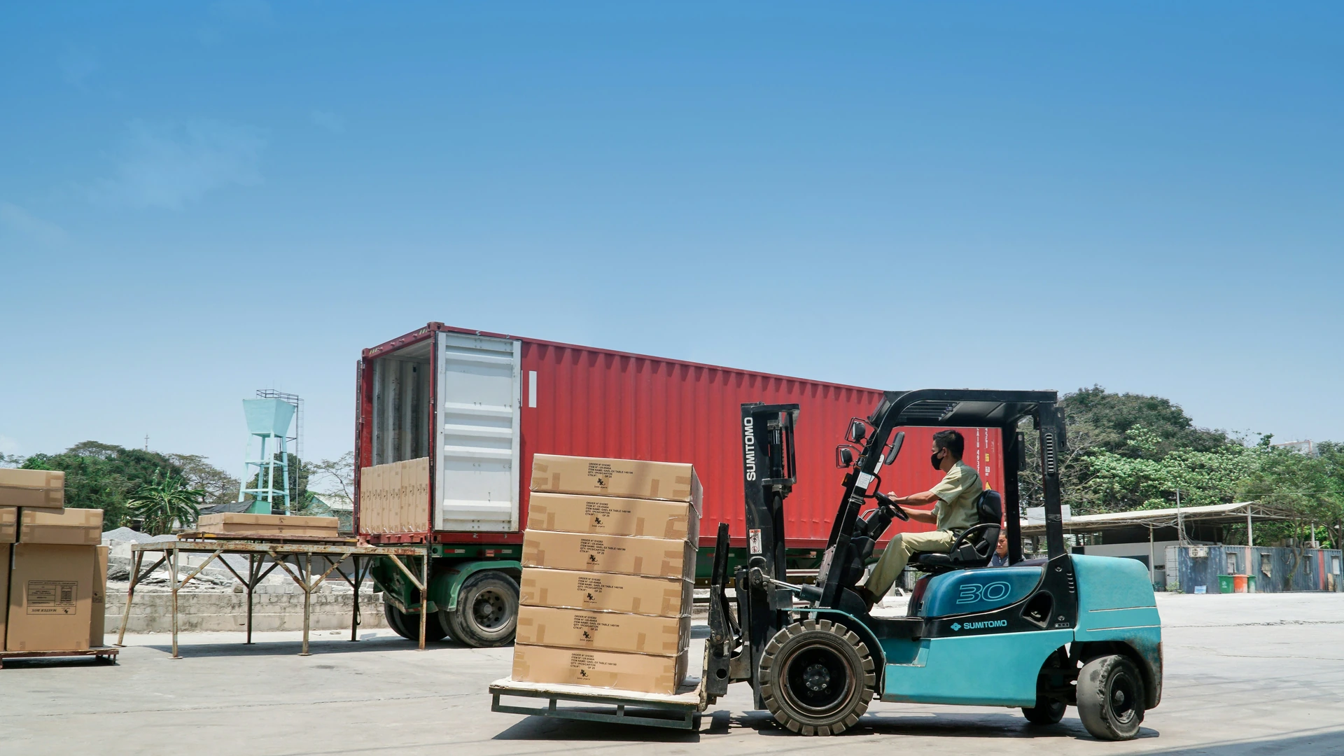 Forklift loading palletized chemical cargo into ocean shipping container for PureEpox export