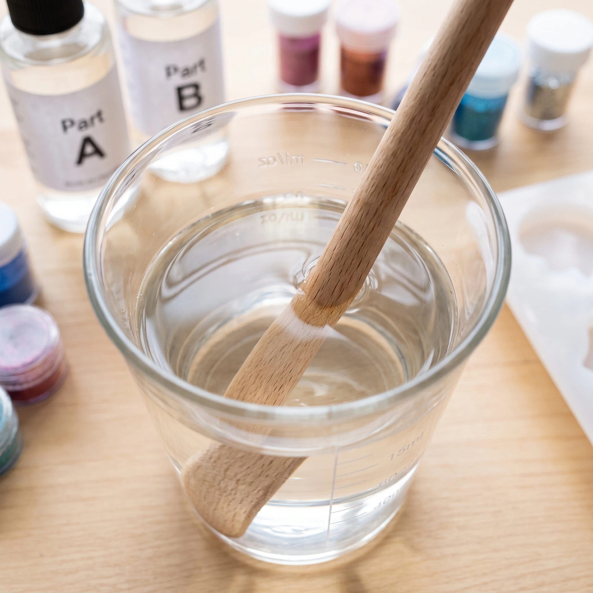 Epoxy resin measured and mixed with cups and stirring sticks